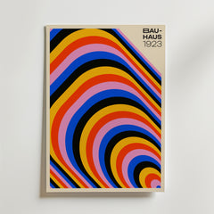Bozetto Bauhaus Arches Poster har djärva, färgglada böjda ränder - gul, orange, röd, lila, blå och svart - på en beige bakgrund med "BAUHAUS 1923" i svart längst upp till höger för en modern, konstnärlig touch.