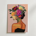 Floral Hair Portrait Poster by Bozetto föreställer en kvinna i svart axelbandslös klänning med huvudet som en livlig blombukett mot en mjuk rosa bakgrund, tryckt på premiumpapper med en lyxig matt finish.