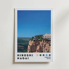 Bozetto Hiroshi Nagai Mountain Estate Poster visar en stiliserad palatslikt hem på en klippa med gröna kullar, blå himmel, "Hiroshi Nagai, Tokyo 1973" längst ner och fem färgprickar.