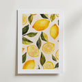 Poster Sunny Slices Poster by Bozetto är en inramad konstprint med hela citroner, citronskivor och gröna blad på vit botten, tryckt på premiumpapper.
