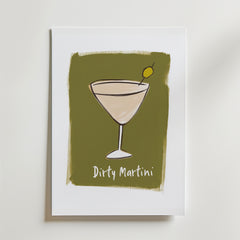 Bozetto Dirty Martini Poster har en minimalistisk cocktaildesign med en grön olivgarnering på en olivgrön bakgrund. Tryckt på premiumpapper med lyxig matt yta, "Dirty Martini" visas under glaset.