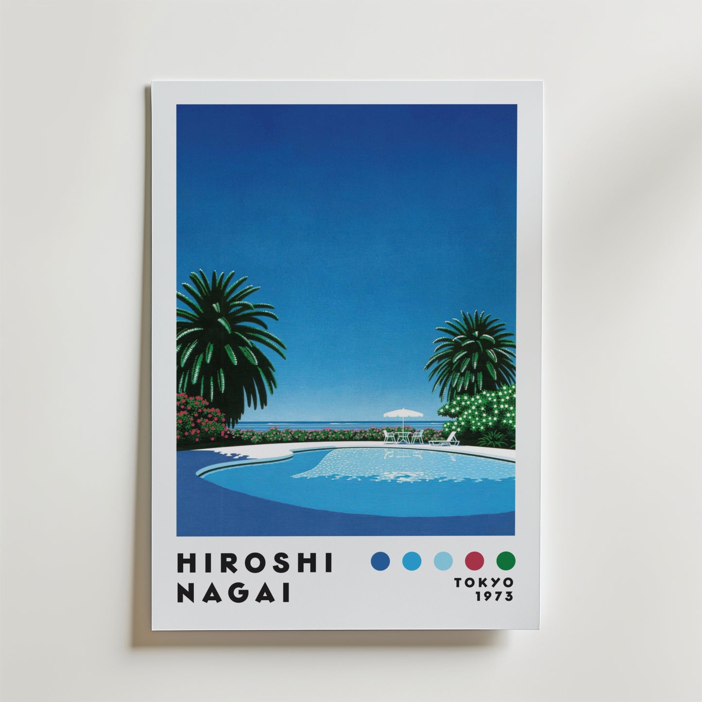 Bozetto Hiroshi Nagai Seaside Pool Poster visar en stiliserad poolscen med palmer, blå himmel, skimrande vatten och schäslonger. "HIROSHI NAGAI" i färgglada prickar och "TOKYO 1973" visas längst ner - perfekt för sommarvibbar.
