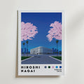 På Bozetto "Hiroshi Nagai Cherry Blossom Avenue Poster" syns en vit byggnad med palmer och två stora rosa körsbärsblomsträd mot en djupblå himmel. Texten nedan visar "Hiroshi Nagai", "Tokyo 1973" och färgade cirklar.