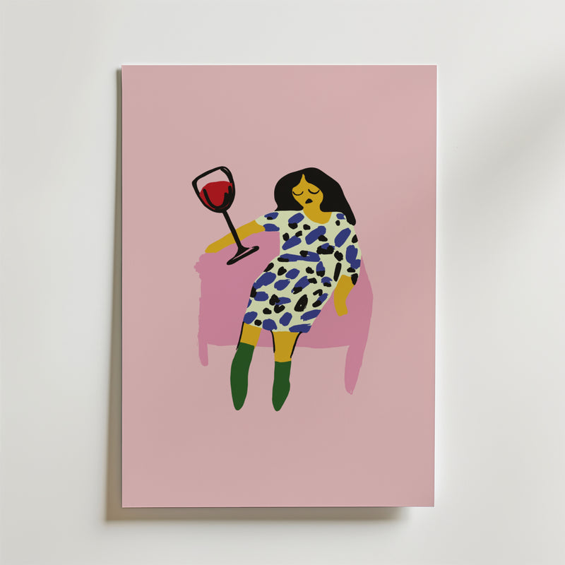 På postern Wine Down Poster från Bozetto syns en minimalistisk kvinna med mörkt hår i en mönstrad klänning och gröna boots, som slappnar av i en rosa stol med rödvin mot en rosa bakgrund. Tryckt på premiumpapper - perfekt för stilfulla inredningar.