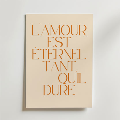 Postern Lamour Est Eternel Tant Quil Dure Poster från Bozetto har orange fransk text på beige, tryckt på premiumpapper med en lyxig matt yta för en sofistikerad look - perfekt för att lyfta alla utrymmen.