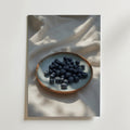 En Bozetto Fresh Blueberry Poster, tryckt på lyxigt premiumpapper, fångar skönheten i färska blåbär på ett mjukt vitt tyg med fläckvis solljus - en elegant touch för alla utrymmen.