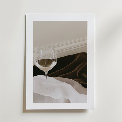 Bozetto Elegance in Silence Drink Poster visar ett halvfyllt vinglas i svart och vit satin mot en vit vägg, tryckt på premiumpapper med en lyxig matt finish och elegant inramad.