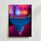 Bozetto Blue Lagoon Drink Poster föreställer ett margaritaglas med saltad kant och limeklyfta, fyllt med en blå cocktail. Den lyxigt matta ytan framhäver levande neonrosa, lila och blå lampor i bakgrunden.