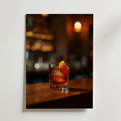 Ett glas cocktail med is och en apelsintwist syns på Bozetto Evening Indulgence Drink Poster, tryckt på premiumpapper med en lyxig matt yta, mot varma, suddiga lampor och hyllor i bakgrunden.