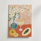 Bozetto Tropical Blossom Poster föreställer vita prästkragar i en blå vas, fruktcocktails, persika och papaya på ett rödorange bord mot mjukt rosa tryckt på premiumpapper med en elegant matt yta.