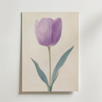 Poster Purple tulip Poster by Bozetto visar en minimalistisk enkel blomma med gröna blad på beige, uppsatt på en vit vägg. Tryckt på FSC-certifierat premiumpapper med lyxig matt yta för en elegant look.