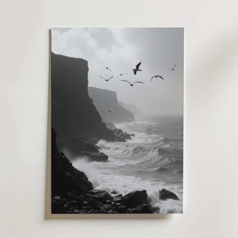 Seaside Flight Poster från Bozetto föreställer en svartvit klippig kustlinje med dramatiska klippor, vågor som slår ner och måsar som flyger under en dimmig himmel. Tryckt på premiumpapper med en lyxig matt finish för en elegant look.