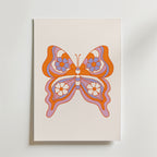 Orange Butterfly Symmetry Poster från Bozetto föreställer en retroinspirerad fjäril med orange, rosa och lila blommiga vingar på en vit bakgrund - ett perfekt och stilfullt tillägg till alla barnrum.