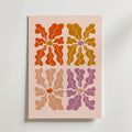Petal Variations Poster från Bozetto visar fyra abstrakta blommor - rödorange, senapsgul, beige och mauve - i ett 2x2 rutnät på ljusrosa. Varje blomma har en rundad mitt och strålande kronblad i mjuka, vågiga nyanser.