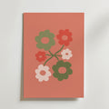 Blossom Cluster Poster från Bozetto har en minimalistisk blomsterdesign med sex retroblommor i grönt, rött och rosa på en enfärgad korallfärgad bakgrund - perfekt för moderna interiörer.