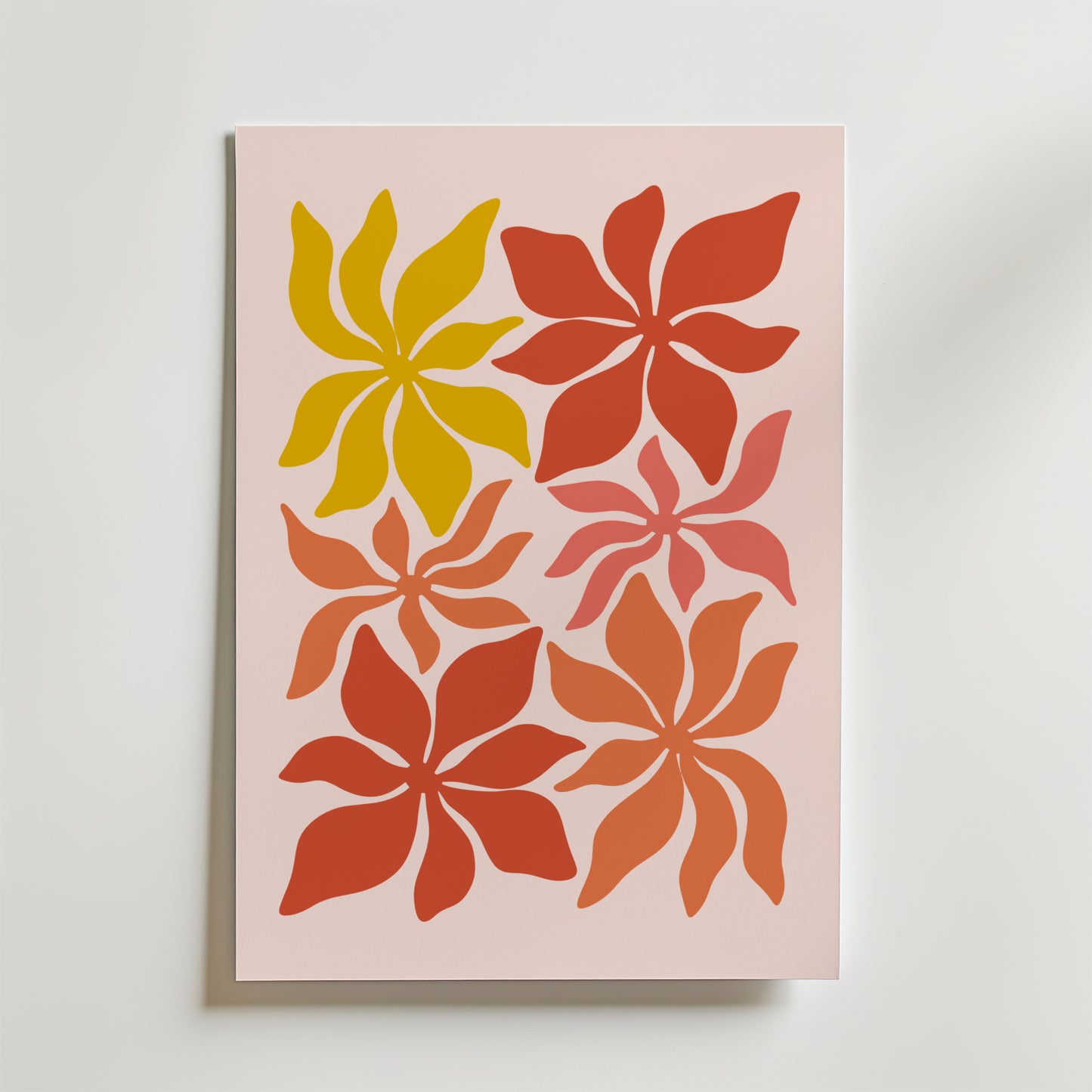 Sunset Petals Poster från Bozetto har sex abstrakta, blomliknande former i varmt gult, orange och rött på en ljusrosa bakgrund, var och en med virvlande kronblad i olika storlekar och riktningar.