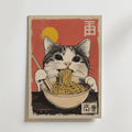 Bozetto Cat Eats Noodle Poster visar en katt i japansk stil som äter nudlar med ätpinnar, mot en röd bakgrund med en gul sol och asiatiska bokstäver i övre högra och nedre hörnen.