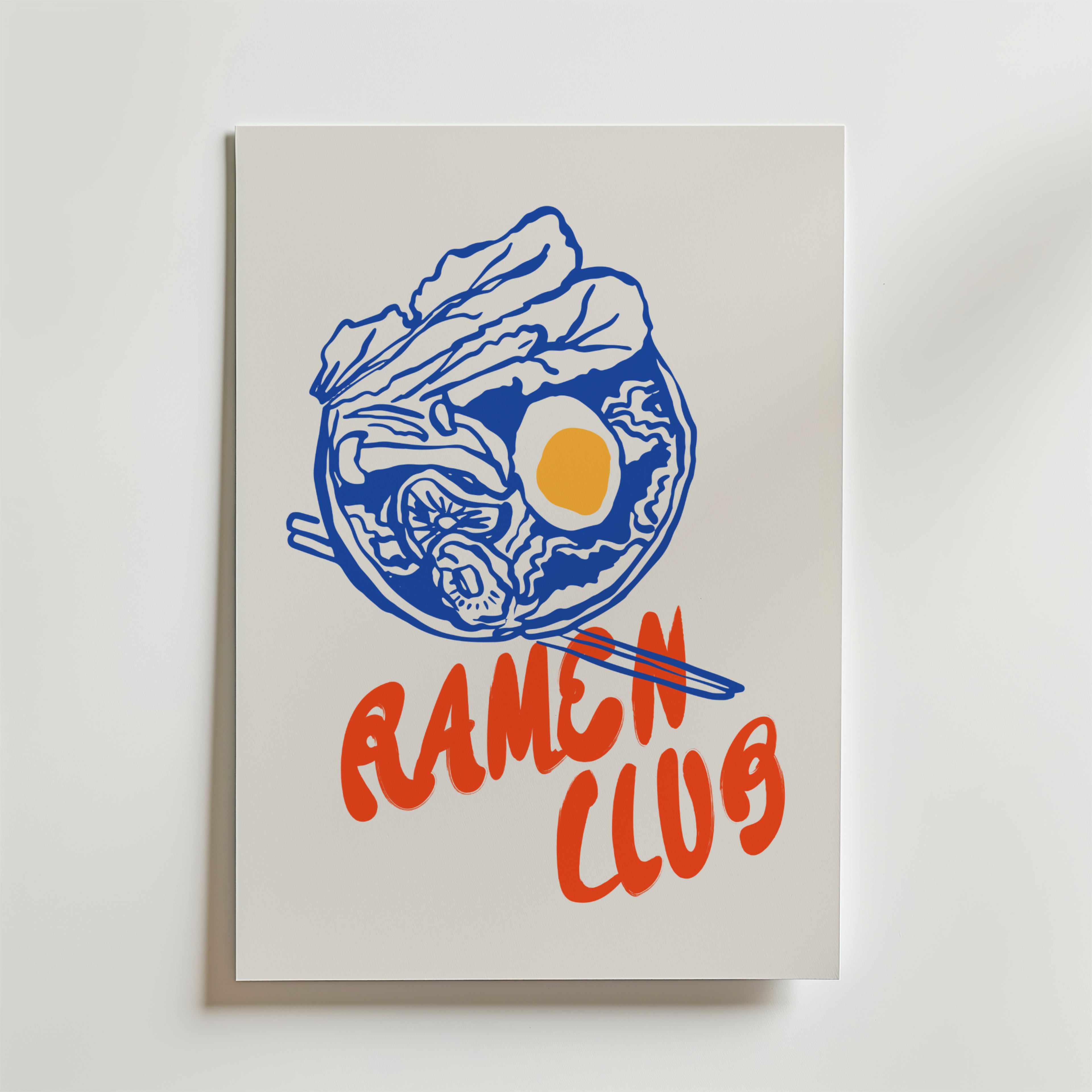 Bozetto Tokyo Diner Poster föreställer en blå ramen bowl med nudlar, ägg, grönsaker, röda ätpinnar och texten RAMEN CLUB - en perfekt köksinredning för dig som gillar japansk comfort food.