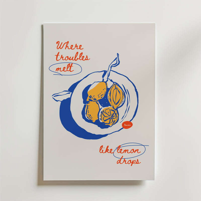 Postern Lemon Drops Poster by Bozetto föreställer en blå och gul illustrerad citron med röd handskriven text: "Där problem smälter som citrondroppar." Perfekt för dig som gillar unik, upplyftande inredning och handritade citroner.