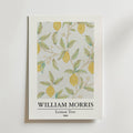 William Morris Lemon Tree Poster by Bozetto föreställer mogna citroner och gröna blad på bleka grenar med små blommor, inramad av vit passepartout och märkt med konstnärens namn och titel.