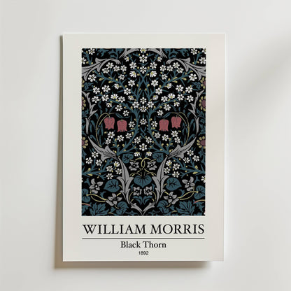 Bozetto William Morris Black Thorn Poster föreställer den ikoniska blomsterdesignen från 1892 med rosor, vita blommor, gröna blad och röda blommor på en mörk bakgrund. Titeln och konstnärens namn visas under konstverket.