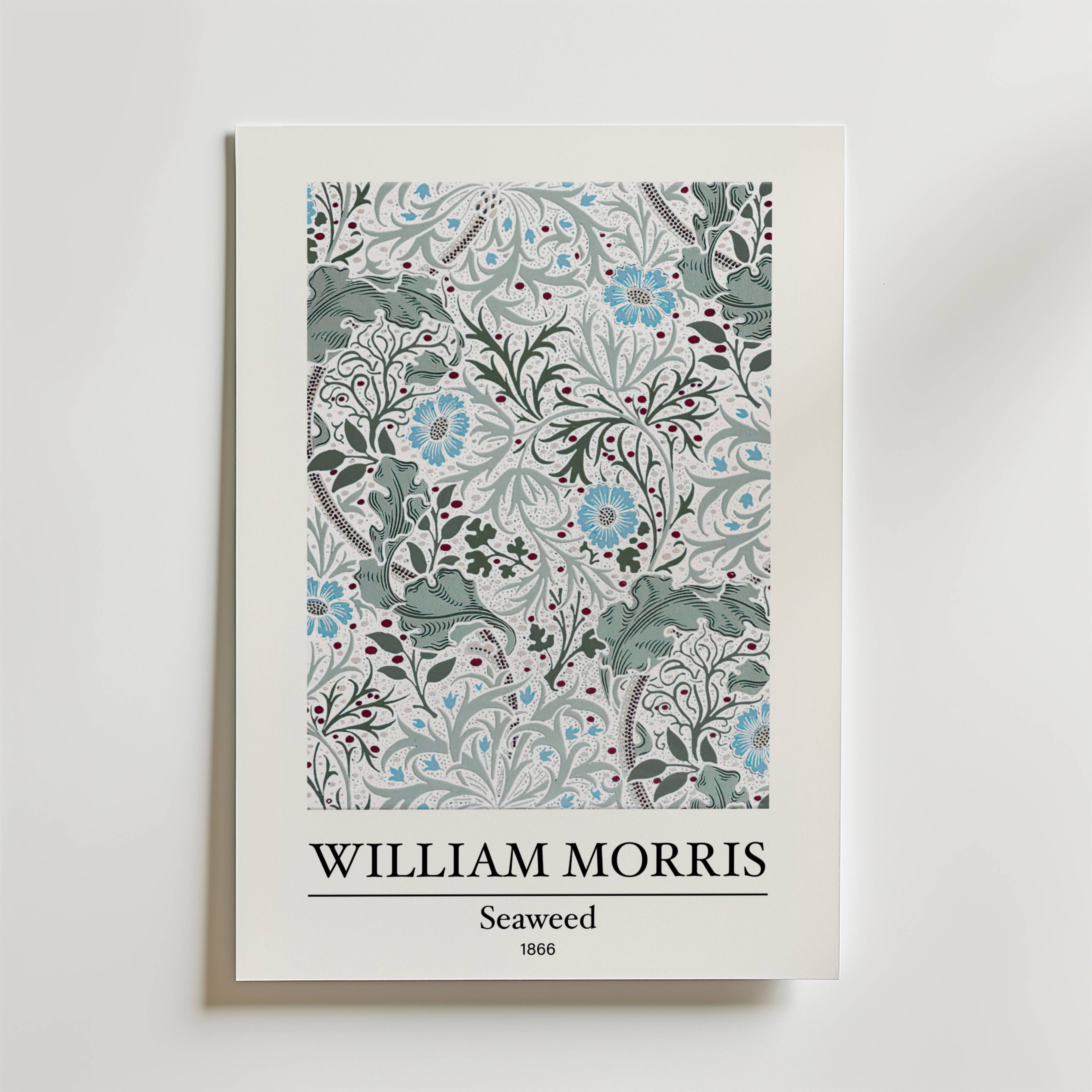 William Morris Seaweed Poster by Bozetto har designen Seaweed från 1866, inspirerad av havets växter, med intrikata blom- och bladmönster i blå och gröna toner. Text: WILLIAM MORRIS WILLIAM MORRIS Seaweed 1866.