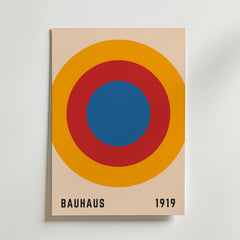 Bozetto Bauhaus Target Poster har koncentriska blå, röda och orange cirklar på beige med "BAUHAUS" och "1919" i svart - perfekt för dig som gillar grafisk design och vill ha en minimalistisk stil.