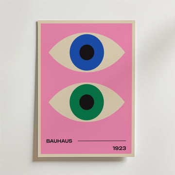 Bauhaus Dual Vision Poster by Bozetto föreställer två stiliserade ögon - ett blått och ett grönt - på en rosa bakgrund med 