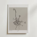 Floral Reverie Poster" från Bozetto föreställer minimalistiska blommor i en vas med svarta linjer på en neutral grå bakgrund, inramad av en vit kant. Denna eleganta poster tillför modern stil och raffinerad blomsterkonst till din inredning.