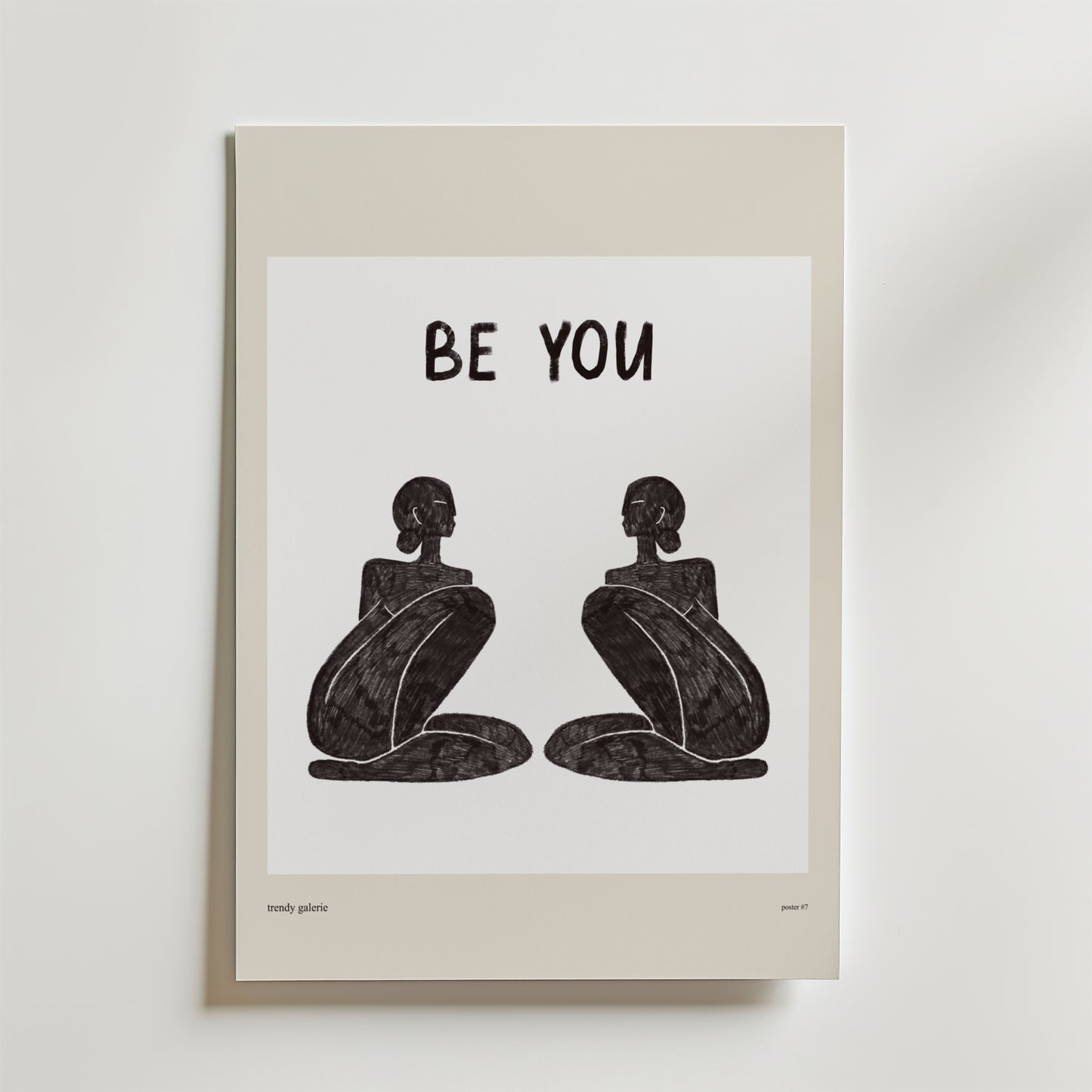 Be Your Poster från Bozetto föreställer två abstrakta, sittande svarta figurer som står vända mot varandra under en fet "BE YOU"-text som inspirerar till autenticitet på en vit bakgrund med en beige kant.