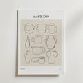 Postern Clay And Character Poster från Bozetto har minimalistiska svarta linjeteckningar av abstrakt keramik och vaser på en beige bakgrund, vilket ger kreativ inredning till alla rum. Postern visas uppställd mot en vit vägg.