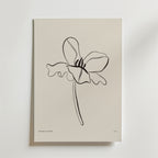 Postern Born To Unfold från Bozetto har minimalistiska svarta linjer av en enda bredbladig blomma med en vågig stjälk på en benvit bakgrund - ett lugnt och modernt blomsterprint för alla rum.